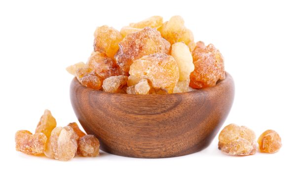 Frankincense resin in wooden bowl, isolated on white background. Pile of natural frankincense Olibanum. Incense.